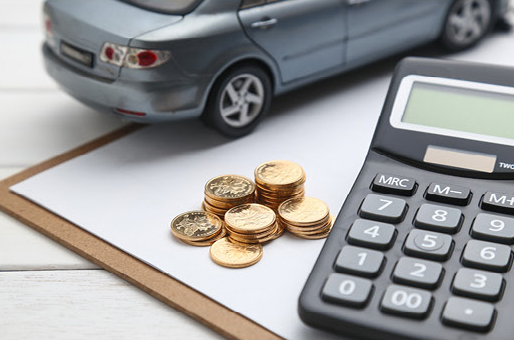 Calculator and coins representing car payment and financing costs