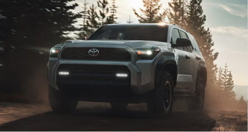 Toyota 4Runner SUV traveling on a dirt road through a forested outdoor landscape