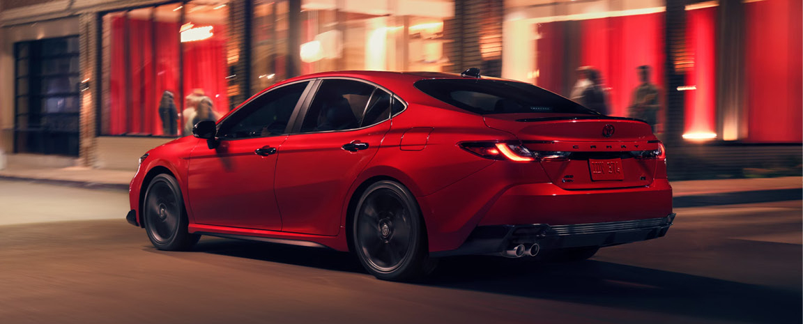 Toyota Camry XSE cruising through an urban entertainment district showcasing sporty design and dynamic handling