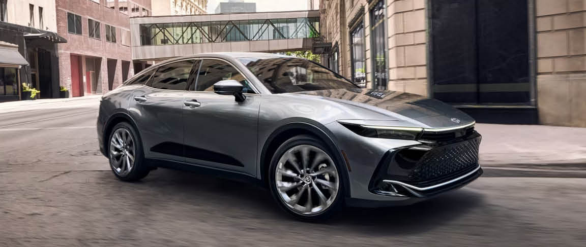 Toyota Crown sedan driving through a modern city street