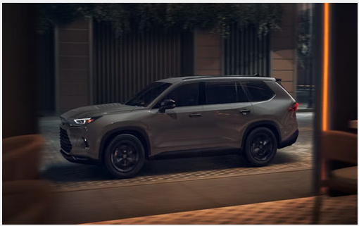 Toyota Grand Highlander driving through an upscale urban setting with refined exterior design