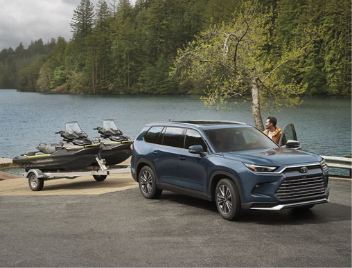 Toyota Grand Highlander parked lakeside with personal watercraft trailer demonstrating family adventure versatility