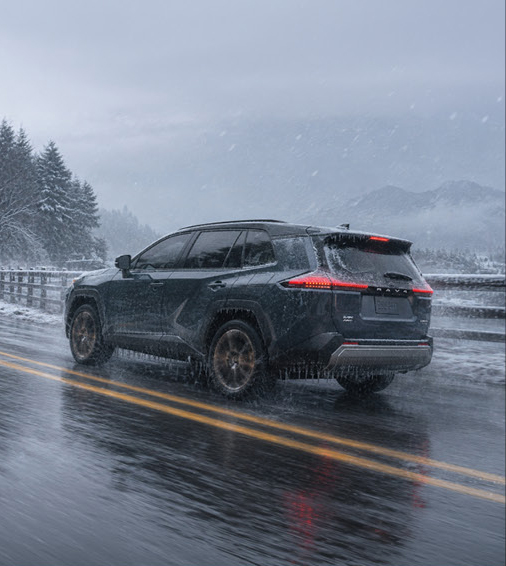 Toyota RAV4 SUV driving on a snowy highway during a winter storm