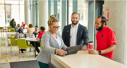 college staff members collaborating with students at a campus information desk