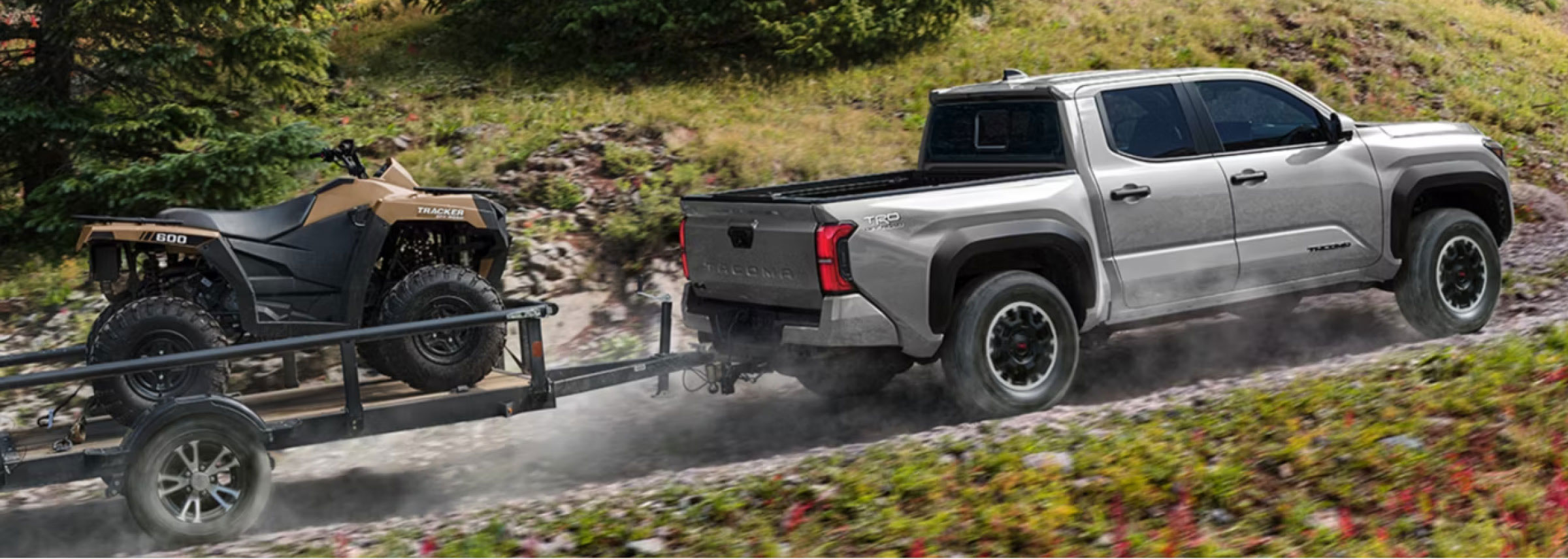 A Toyota Tacoma pulling a trailer with a 4wheeler on it