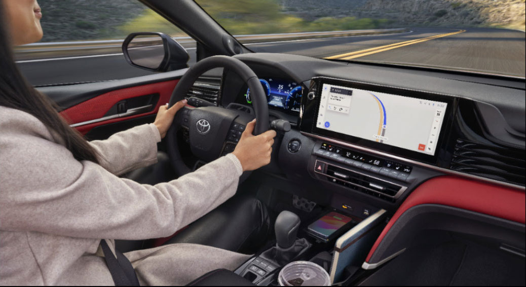 Toyota interior view showing driver using navigation system on a widescreen infotainment display