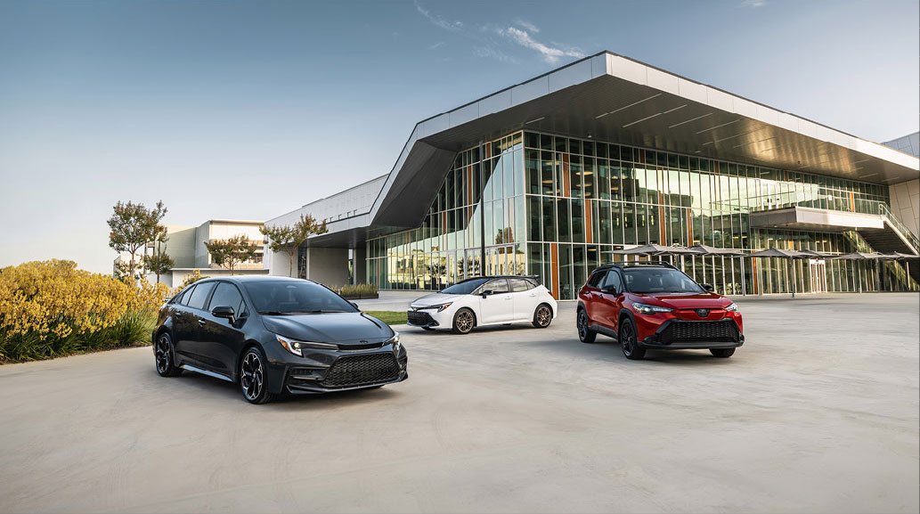 Toyota vehicle lineup displayed outside a modern building featuring hybrid and gas models
