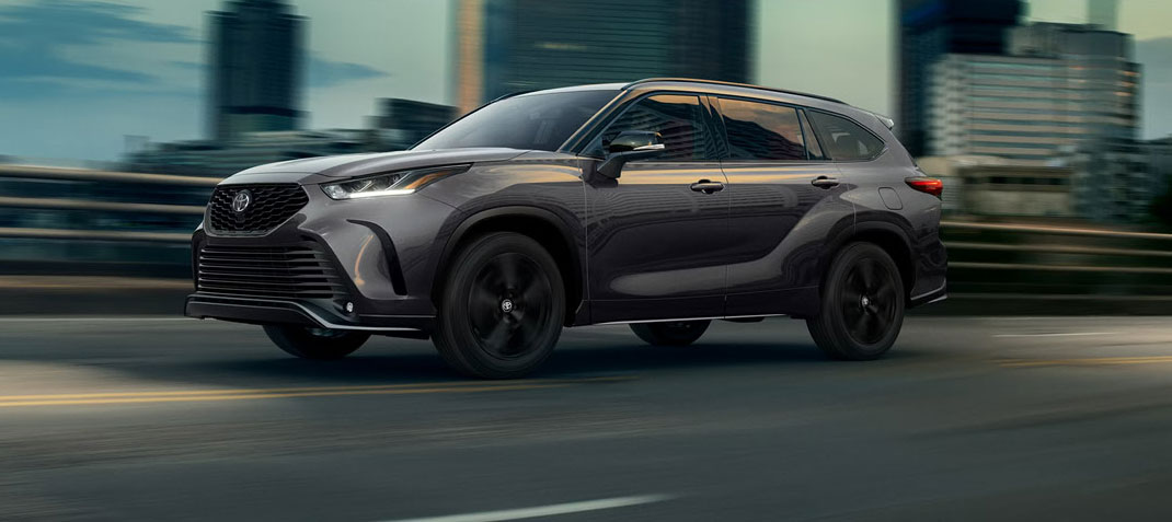 Toyota Grand Highlander driving through an urban city setting