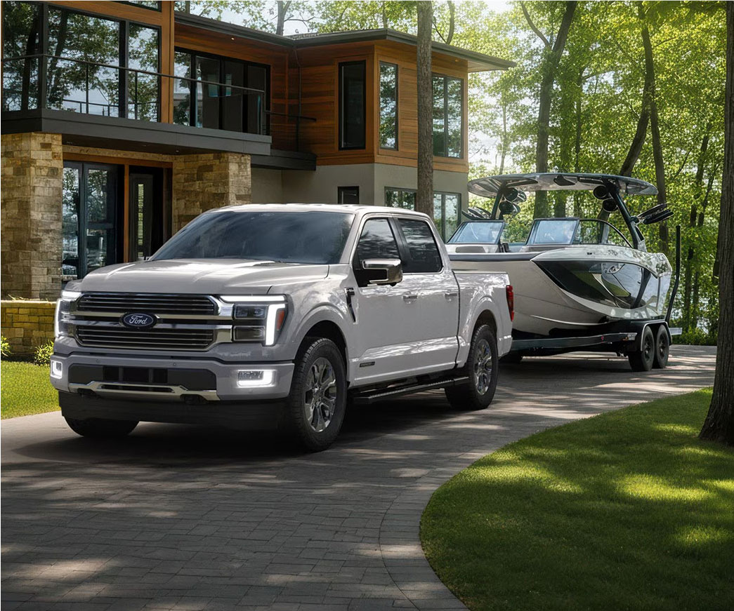 Ford F-150 pickup truck towing a boat in a residential driveway