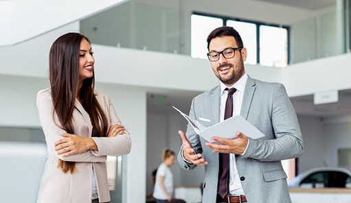 Car dealership representative discussing vehicle purchase options with a customer