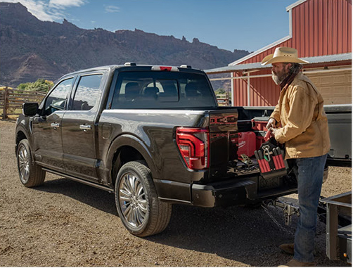 Ranch worker loading tools into the bed of a Ford F-150 pickup truck