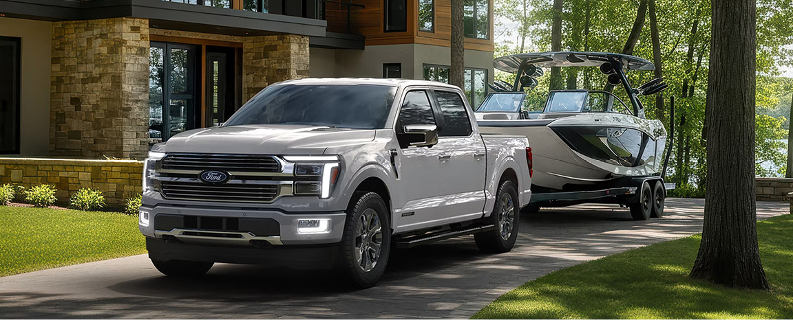 Ford F-150 towing a premium wake boat from a lakeside home showcasing exceptional towing capability and truck versatility