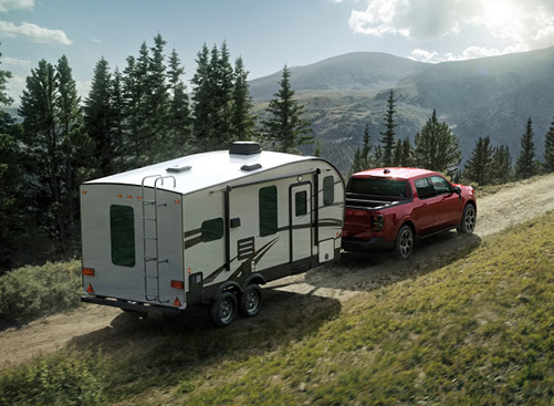 Ford F-150 hauling a travel trailer through mountainous terrain highlighting impressive towing power for outdoor adventures