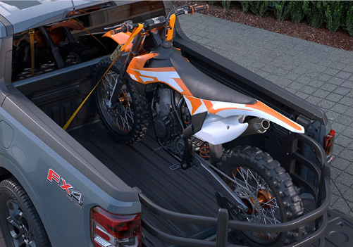 Ford F-150 truck bed carrying a dirt bike showcasing cargo versatility, secure hauling solutions, and practical utility