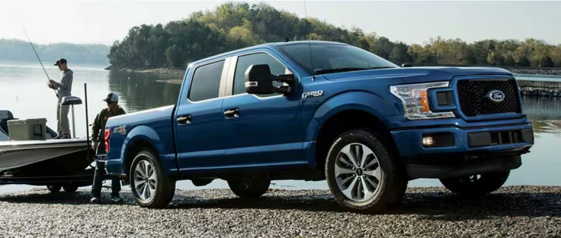 A Ford F-150 pulling a boat out of the lake