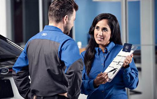 Ford service advisor explaining maintenance schedule and service recommendations to customer