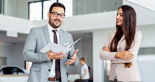 Car dealership salesperson explaining financing options to a customer