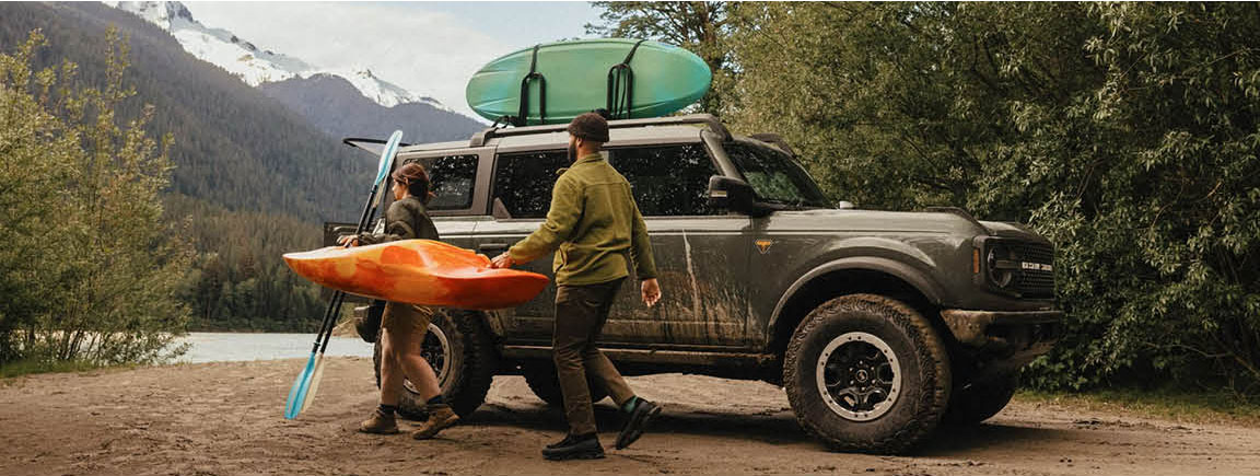 Ford Bronco SUV parked outdoors with kayaks and outdoor adventure gear