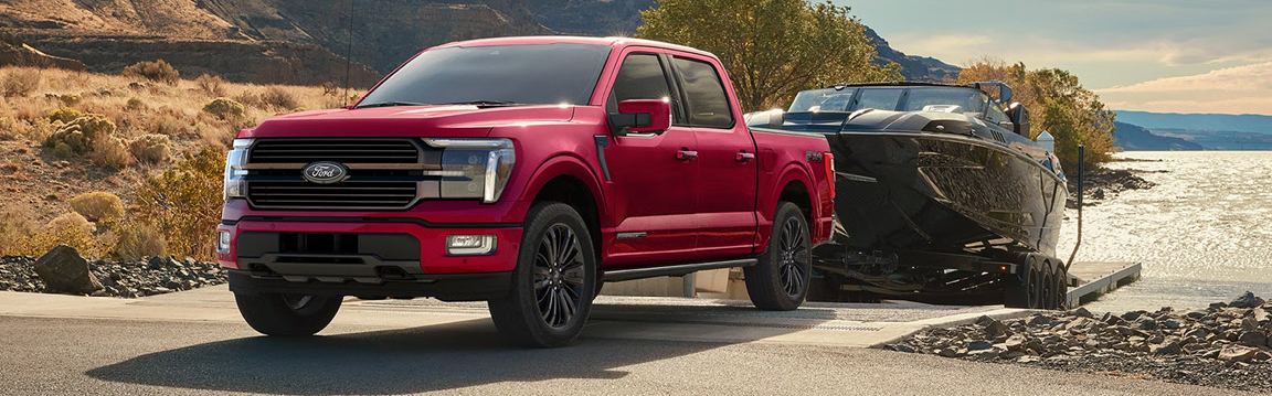 Ford F-150 towing a boat at a lakeside launch ramp