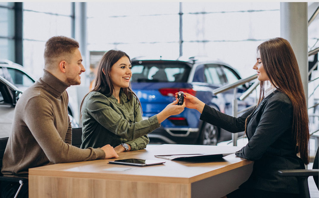 Customer receiving car keys from dealership representative during purchase
