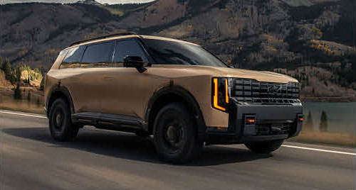 Kia Telluride SUV driving on a mountain road at sunset