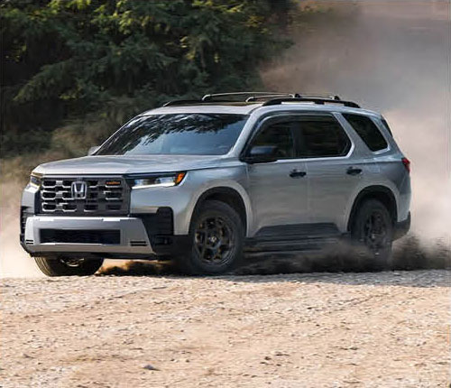 Honda Pilot SUV driving on a dirt road with dust trail