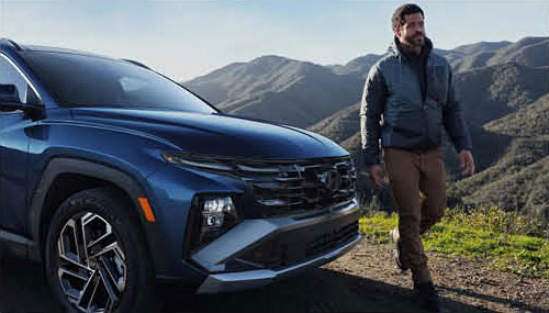 Hyundai Tucson SUV parked with driver enjoying mountain view