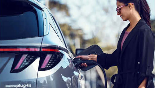 Hyundai Tucson plug-in hybrid charging with driver plugging in vehicle