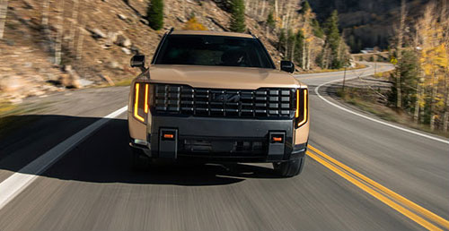 Kia Telluride driving on mountain road with bold front grille design