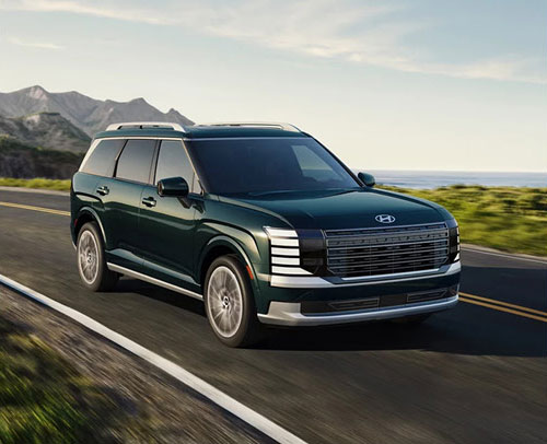 Hyundai Palisade SUV driving on highway with modern exterior styling