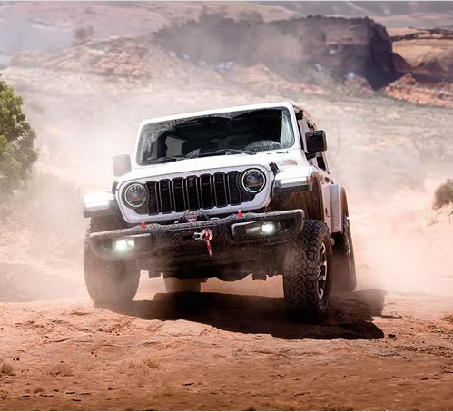 Jeep Wrangler Rubicon navigating a rugged desert trail with off-road recovery equipment