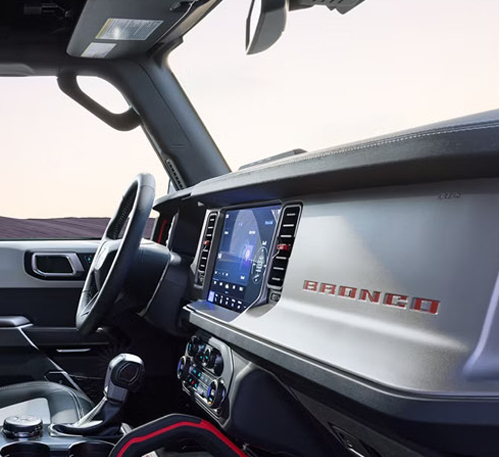 Ford Bronco interior featuring digital touchscreen, dashboard controls, and rugged cabin design
