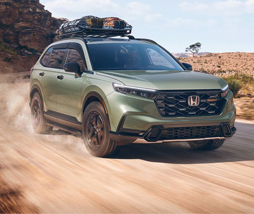 Honda CR-V TrailSport driving on a dusty off-road trail, showcasing rugged styling, all-terrain confidence, and outdoor adventure capability