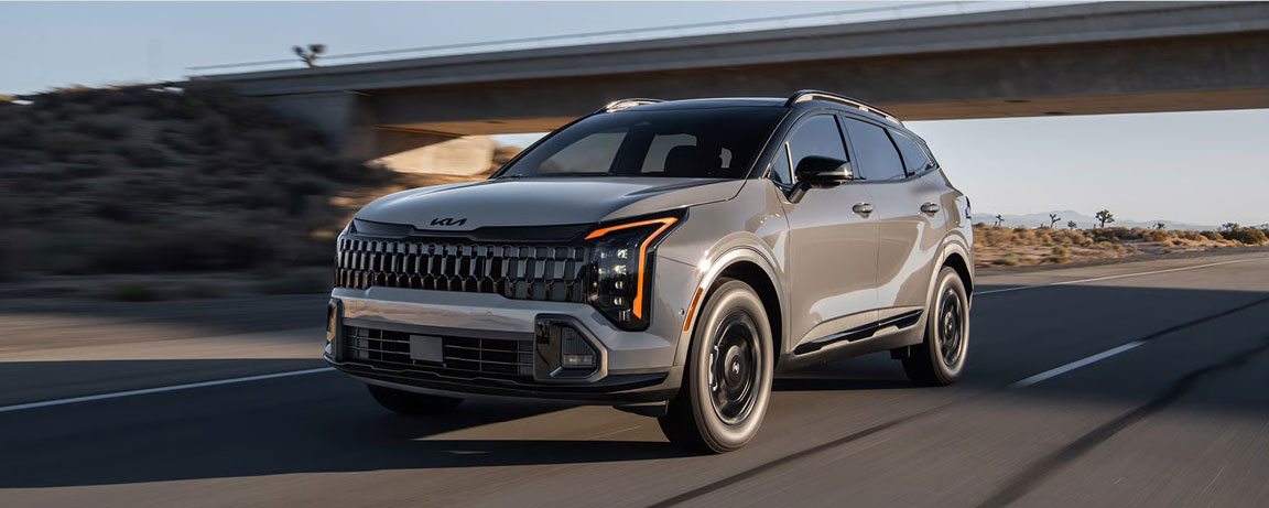 Kia Sportage driving on an open highway, showcasing bold styling, efficient performance, and modern SUV innovation