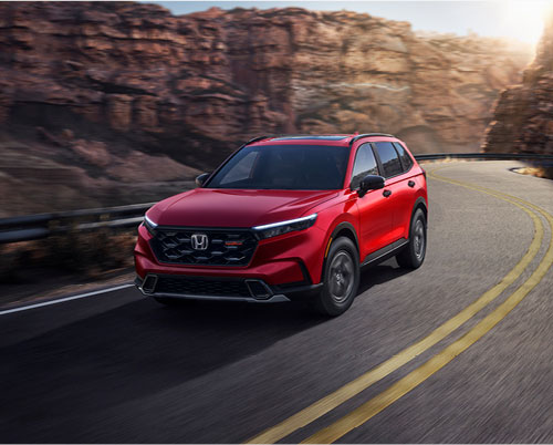 Honda CR-V driving through a scenic mountain highway, showcasing confident performance, modern styling, and everyday SUV versatility