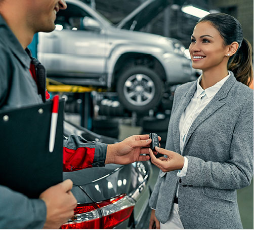 Customer receiving vehicle keys from a service advisor, representing professional automotive service, maintenance support, and customer satisfaction