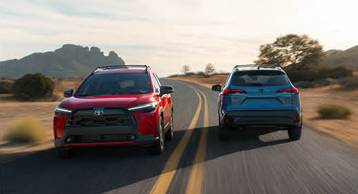 Toyota RAV4 SUVs driving side by side on a desert highway