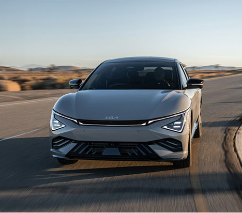 Kia EV6 electric crossover driving on an open highway with modern LED lighting