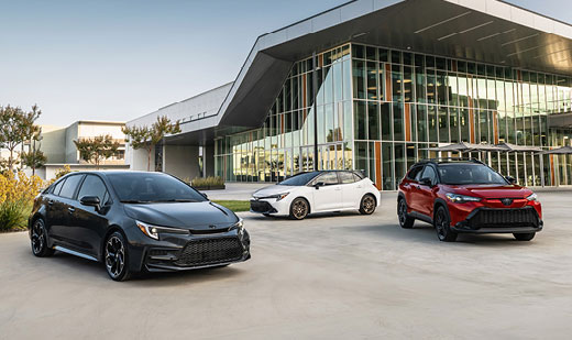 3 Toyota vehicles parked outside of a dealership showroom