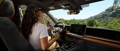 Woman sitting inside Volkswagen Tiguan enjoying scenic mountain view