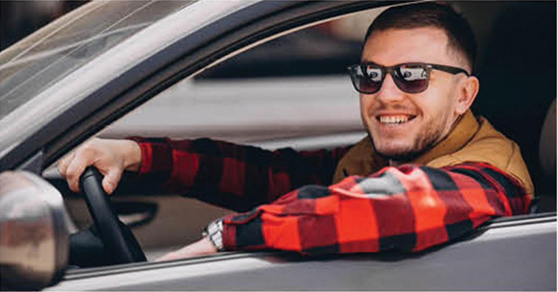 Man smiling while driving a car