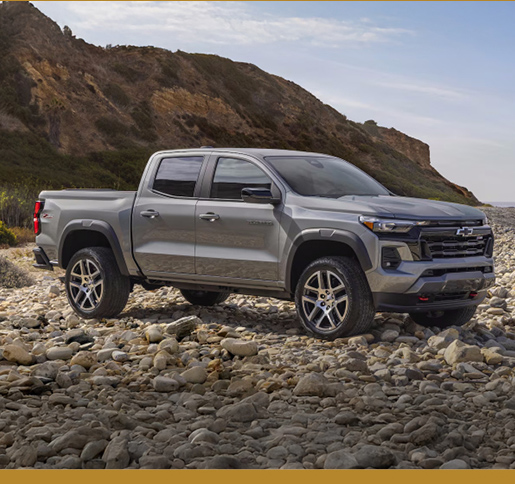 Chevrolet Colorado pickup truck parked on rocky terrain near mountains