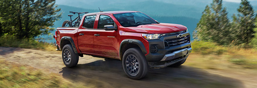 Chevrolet Colorado driving on mountain trail carrying bike in truck bed