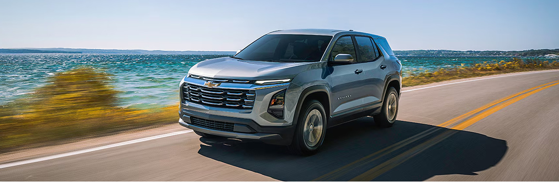 Chevrolet Equinox driving on coastal highway with ocean in background