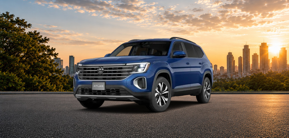 Volkswagen Atlas SUV parked with a city skyline at sunset showcasing bold styling, three-row versatility, and urban-ready capability