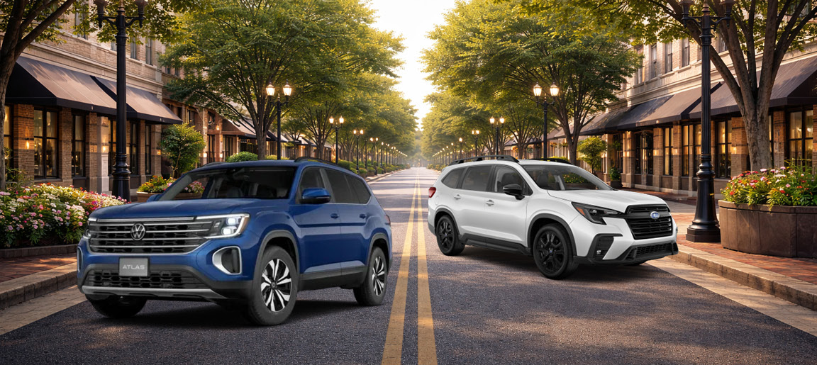 Volkswagen Atlas and Subaru Ascent SUVs parked on a city street comparison