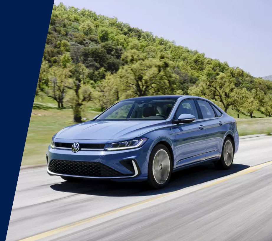 Blue Volkswagen sedan front view driving on a road