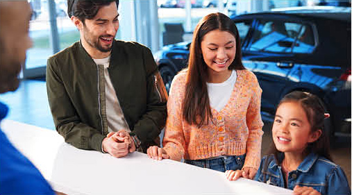 Family speaking with a sales consultant inside a Volkswagen dealership showroom