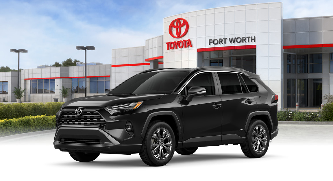 Toyota RAV4 hybrid SUV parked in front of Toyota dealership in Fort Worth