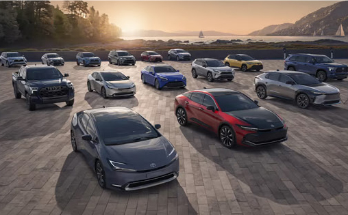 Toyota vehicle lineup displayed with multiple models on a scenic waterfront